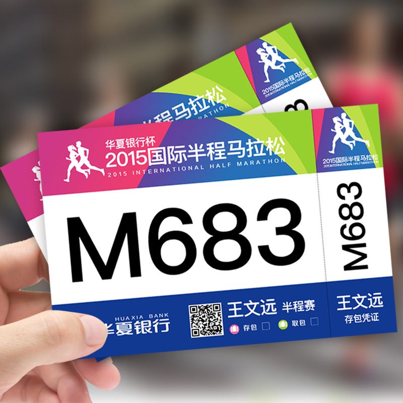 Custom printed race bibs with event branding, race number M683 and a tear-off bag check voucher