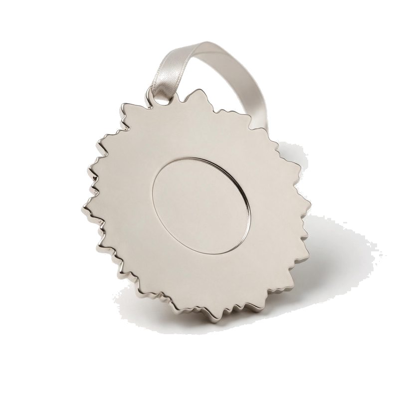 reverse of a die-cast wreath christmas ornament showing the plain nickel back and recessed centre panel
