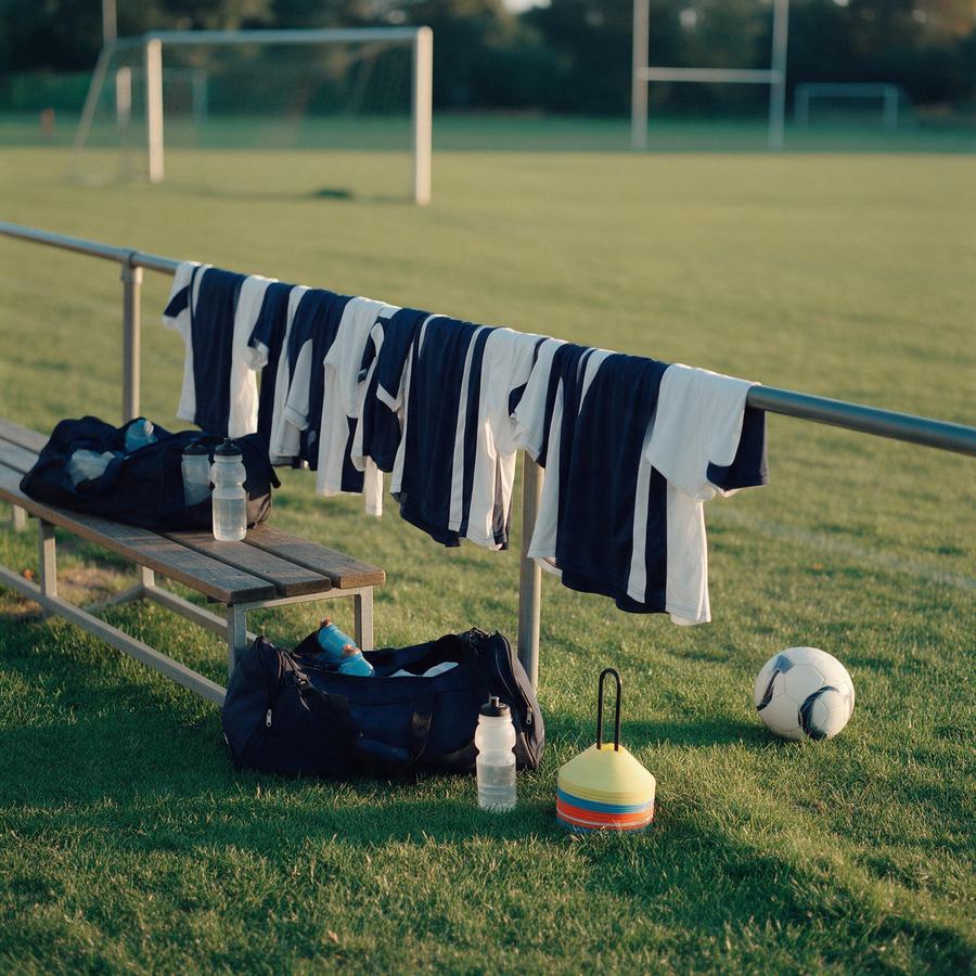 Sports club training ground with team kits, bench and goals