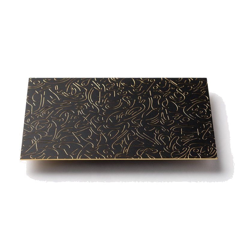 matte black metal business card with fine gold etched abstract pattern and a bright gold cut edge