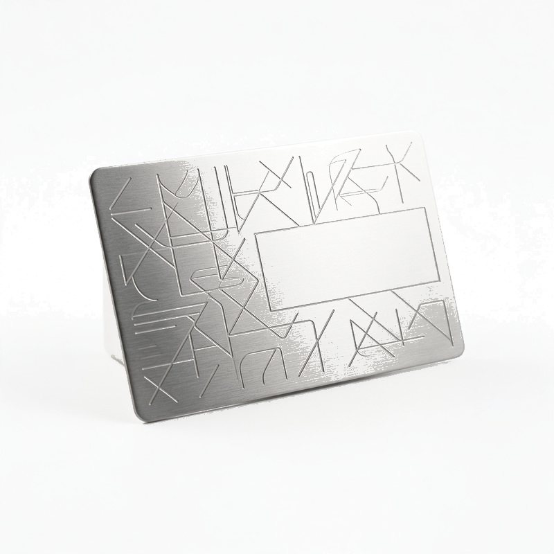 brushed stainless steel business card standing at an angle with a laser etched geometric line pattern