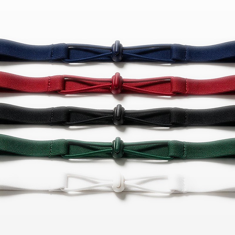 five race number belts in navy, crimson, black, forest green and white laid parallel as a colour chart
