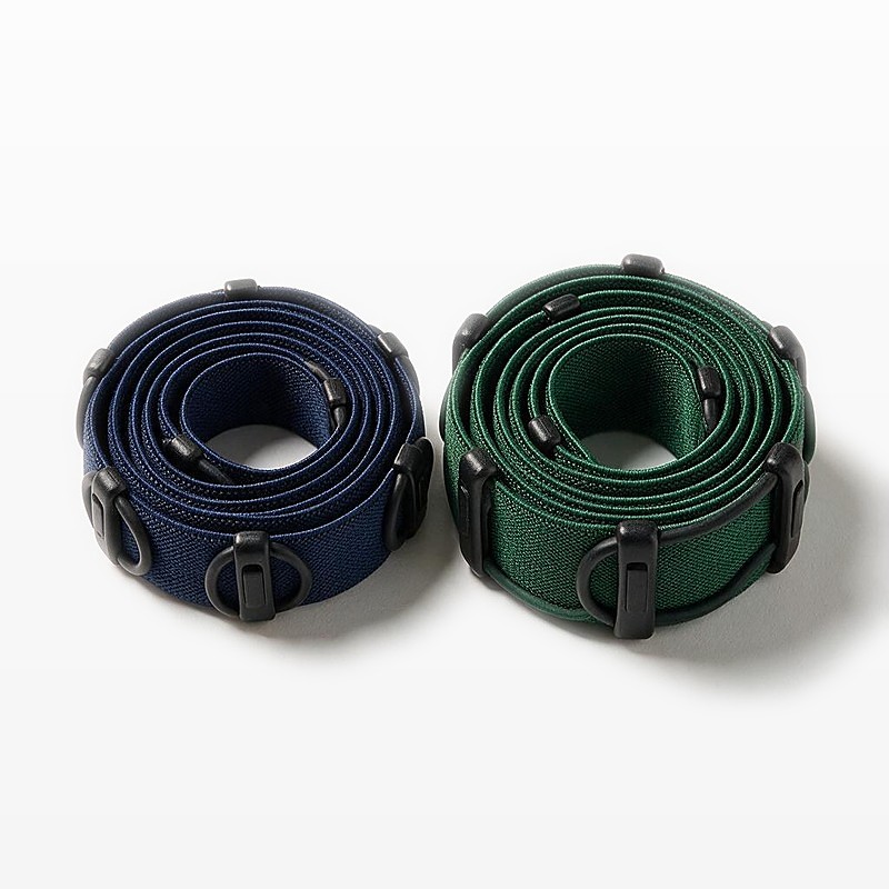 two coiled race number belts side by side showing the 25 mm navy and 38 mm green webbing widths